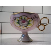 Vintage Pedestal Porzellan Teetasse Goldene Spitze Abzugsring Griff Mauve Mit Handbemalten Blumen Irisierendes Interieur Retro Shower Tea Party Vintage Pedestal Porzellan Teetasse Goldene Spitze Abzugsring Griff Mauve Mit Handbemalten Blumen Irisierendes Interieur Retro Shower Tea Party von 222nest