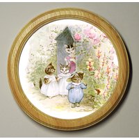 Beatrix Potter Rundes Hölzerner Gerahmter Kunstdruck-Kinderzimmer-Bild-Wandbehang-Plakette Tom-Kätzchen-Moppet Und Handschuhe Im Garten Illustration von BluebellArtandWood