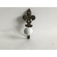 Metall Bronzefarbener Fleur De Lis Wandhaken Mit Weißer Keramik Finial L 3, 25" W 1 3/8" von GillysCollectibles
