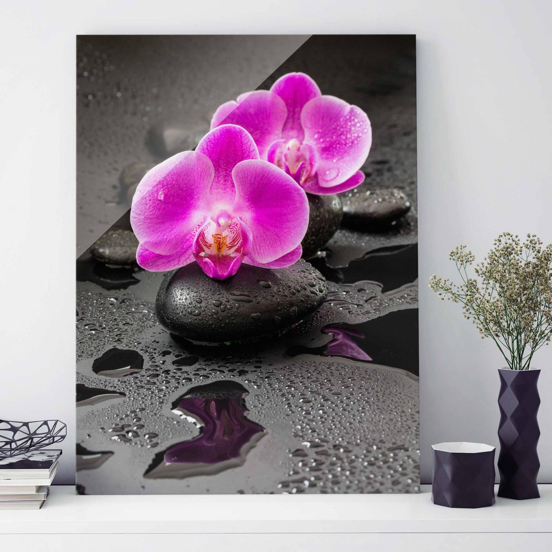 Glasbild Blume Pinke Orchideenblüten auf Steinen mit Tropfen von Klebefieber