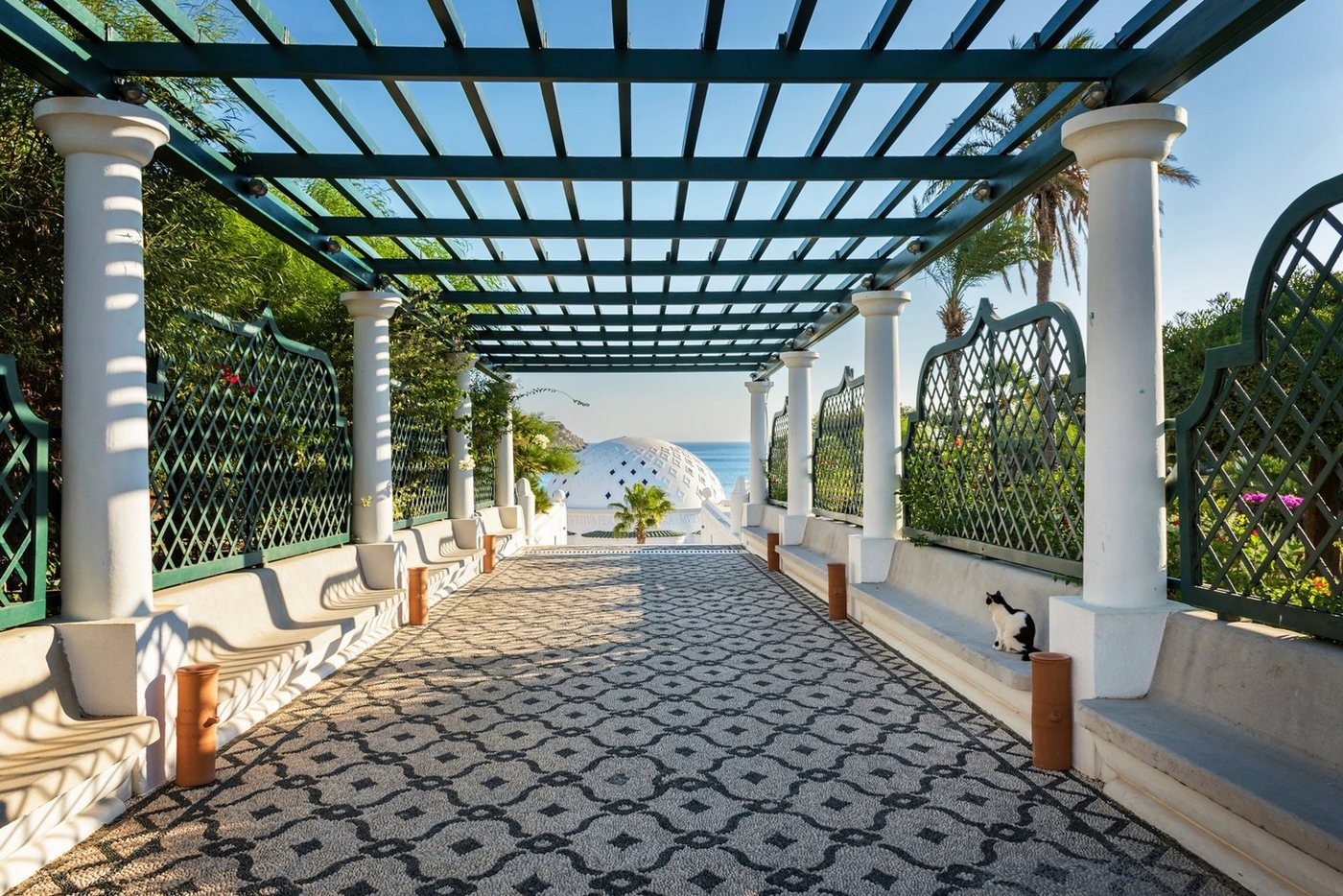 Papermoon Fototapete PERGOLA-RHODOS BLUMEN SEE MEER TERRASSE PALMEN DÜNEN von Papermoon