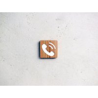 Holzschild Mit Eingraviertem Piktogramm Zur Kennzeichnung Eines Telefons von StudioDoucine