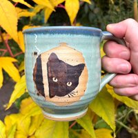 Handgefertigte 350 Ml Tasse in Türkis Mit Tropfen Und Niedlicher Schwarzer Katze - Ein Einzigartiges Trinkvergnügen Handgefertigte 350 Ml Tasse in Türkis Mit Tropfen Und Niedlicher Schwarzer Katze - Ein Einzigartiges Trinkvergnügen von VersandderkleinenHex