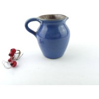 Ein Kleiner Krug Aus Dunkler Keramik Mit Blauer Glasur Überzogen von VintageMuseumShop