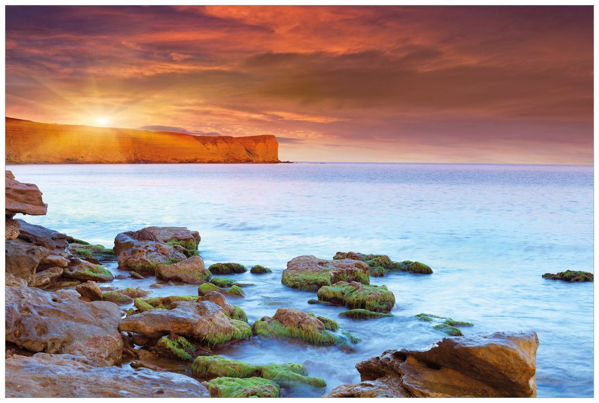 Wallario Acrylglasbild, Sonnenaufgang am Meer mit Landzunge und Felsen im Wasser, in verschiedenen Ausführungen von Wallario