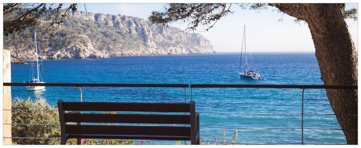 Wallario Glasbild, Einsame Bank am Meer - Spanien im Sommer, in verschiedenen Ausführungen von Wallario