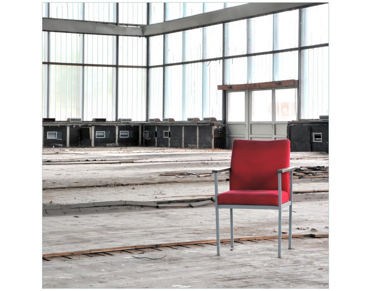 Wallario Möbelfolie Stille und Leere - ein einsamer roter Stuhl in einer alten Halle von Wallario