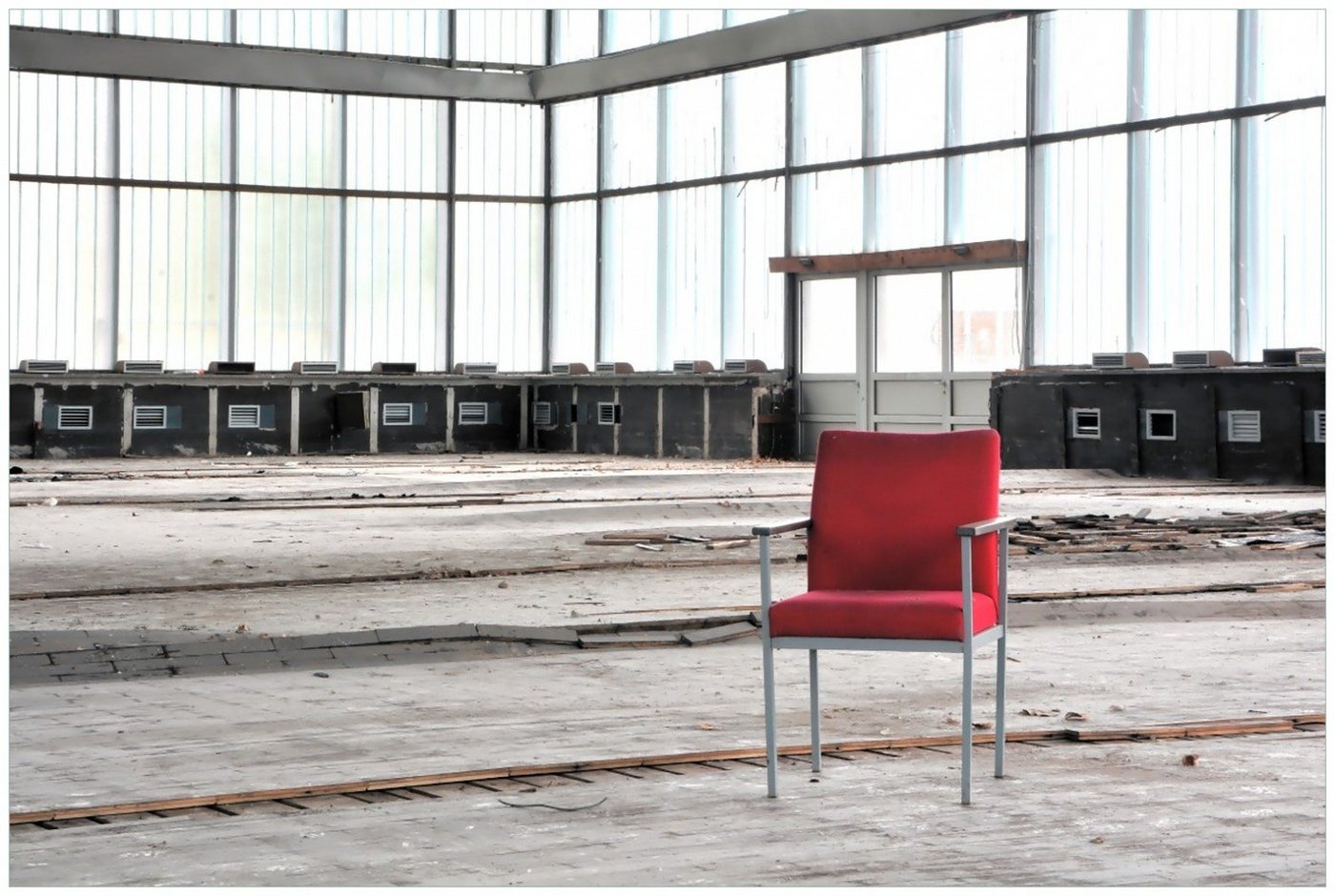 Wallario Poster, Stille und Leere - ein einsamer roter Stuhl in einer alten Halle, in verschiedenen Ausführungen von Wallario