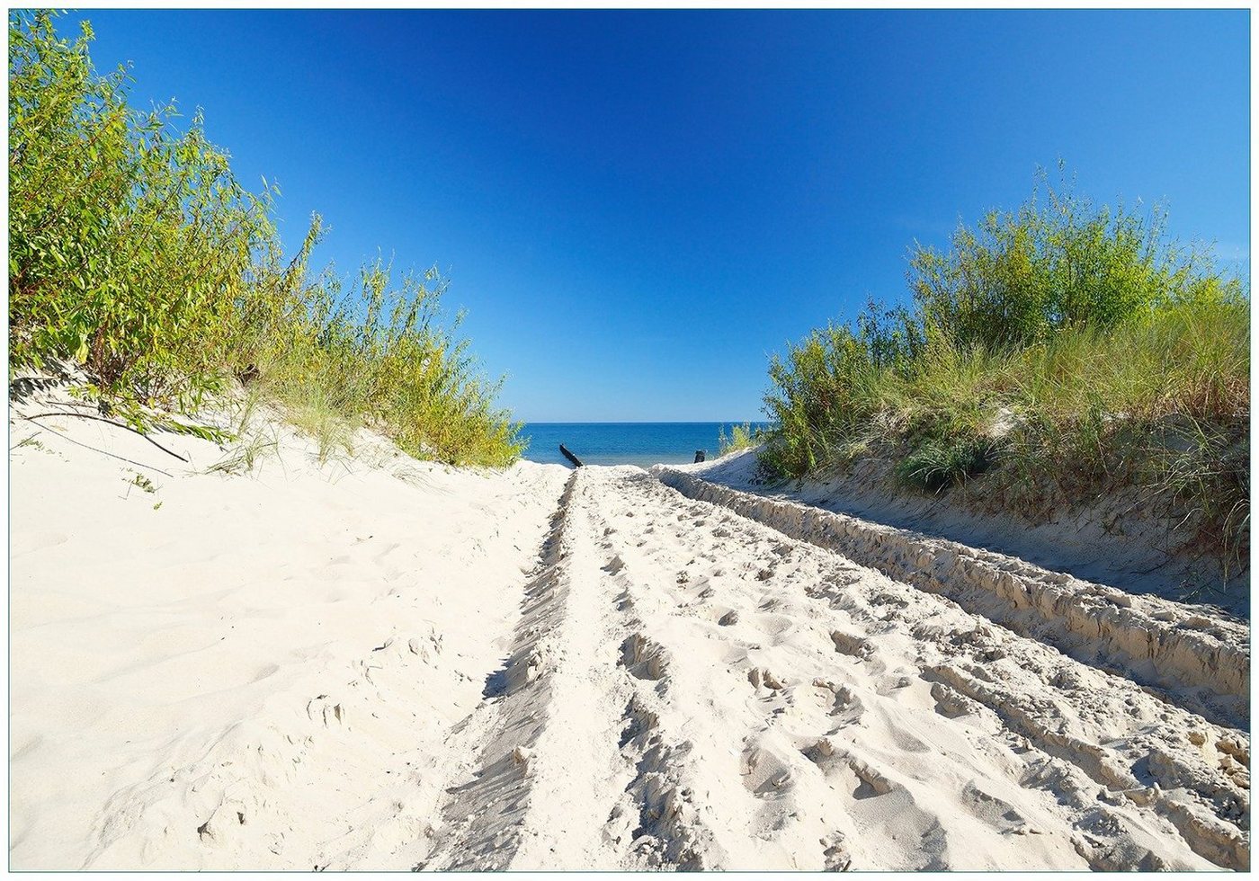 Wallario Vliestapete Auf dem Sandweg zum Strand - Blauer Himmel über dem Meer, Seidenmatte Oberfläche, hochwertiger Digitaldruck, in verschiedenen Größen erhältlich von Wallario