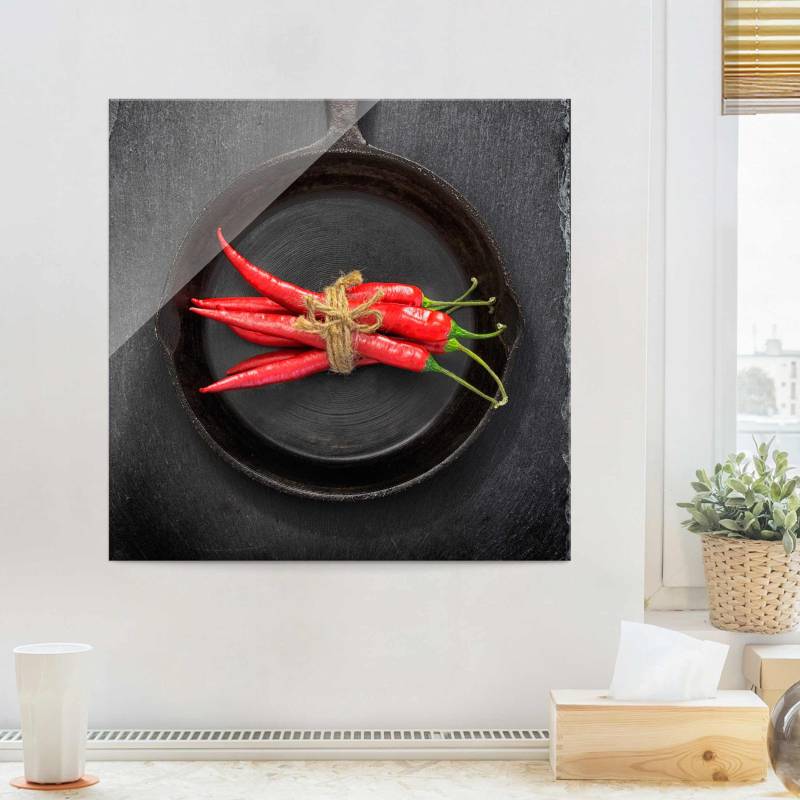 Glasbild Rotes Chilibündel in Pfanne auf Schiefer