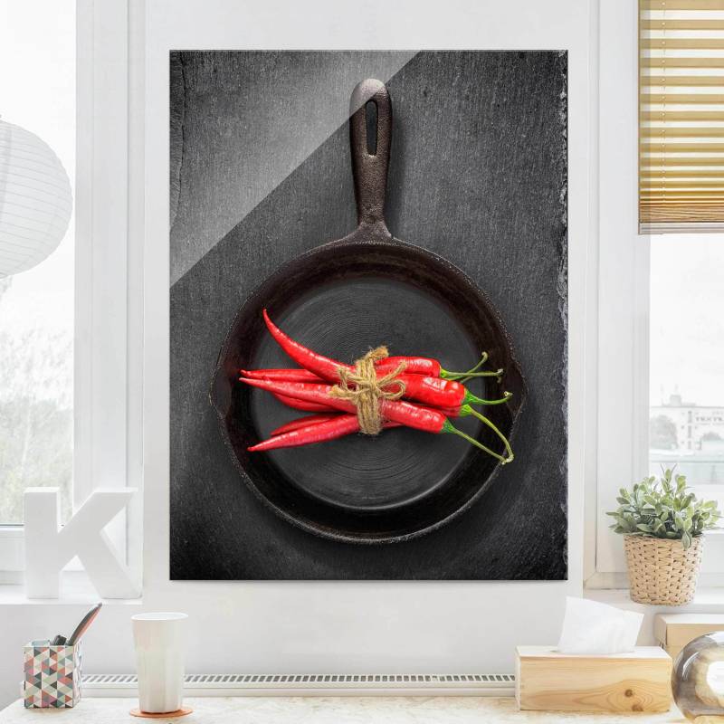 Glasbild Rotes Chilibündel in Pfanne auf Schiefer